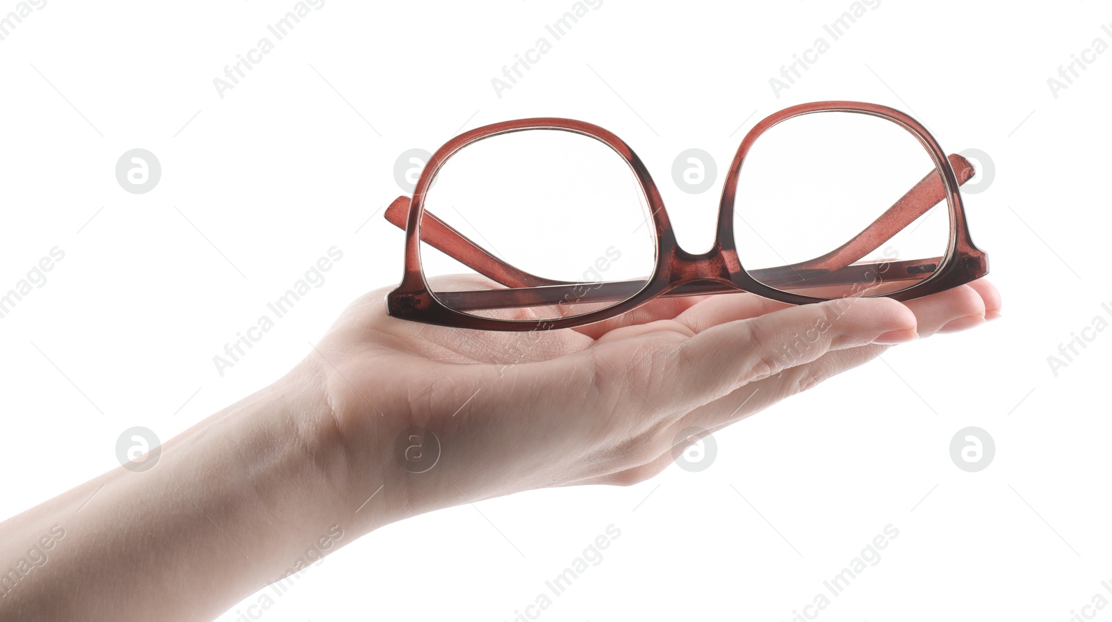 Photo of Woman holding glasses with brown frame on white background, closeup