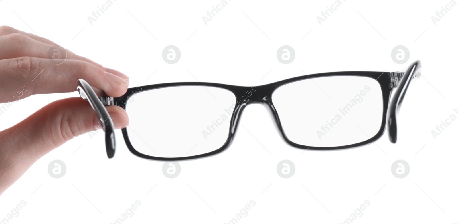 Photo of Woman holding glasses with black plastic frame on white background, closeup