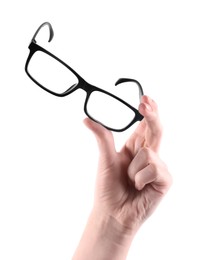 Photo of Woman holding glasses with black plastic frame on white background, closeup