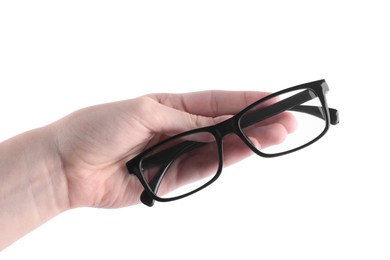 Photo of Woman holding glasses with black plastic frame on white background, closeup