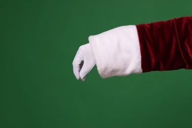 Photo of Santa Claus holding something on green background, closeup. Space for text