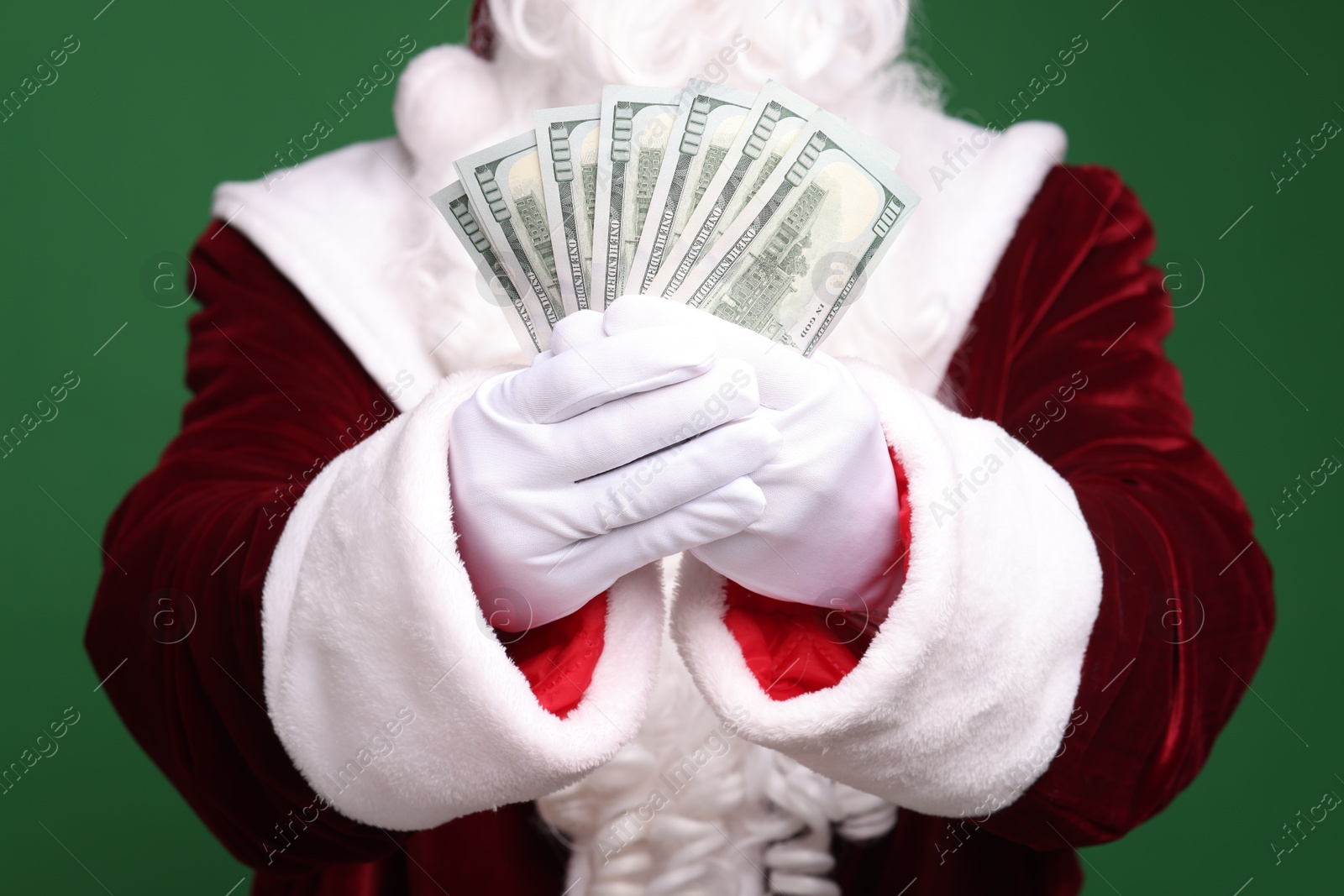 Photo of Santa Claus with dollar banknotes on green background, closeup