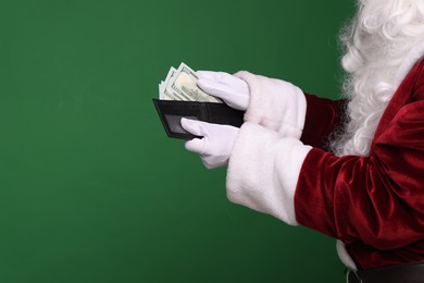 Photo of Santa Claus with dollar banknotes on green background, closeup. Space for text