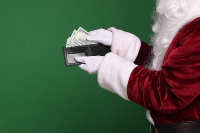 Photo of Santa Claus with dollar banknotes on green background, closeup. Space for text