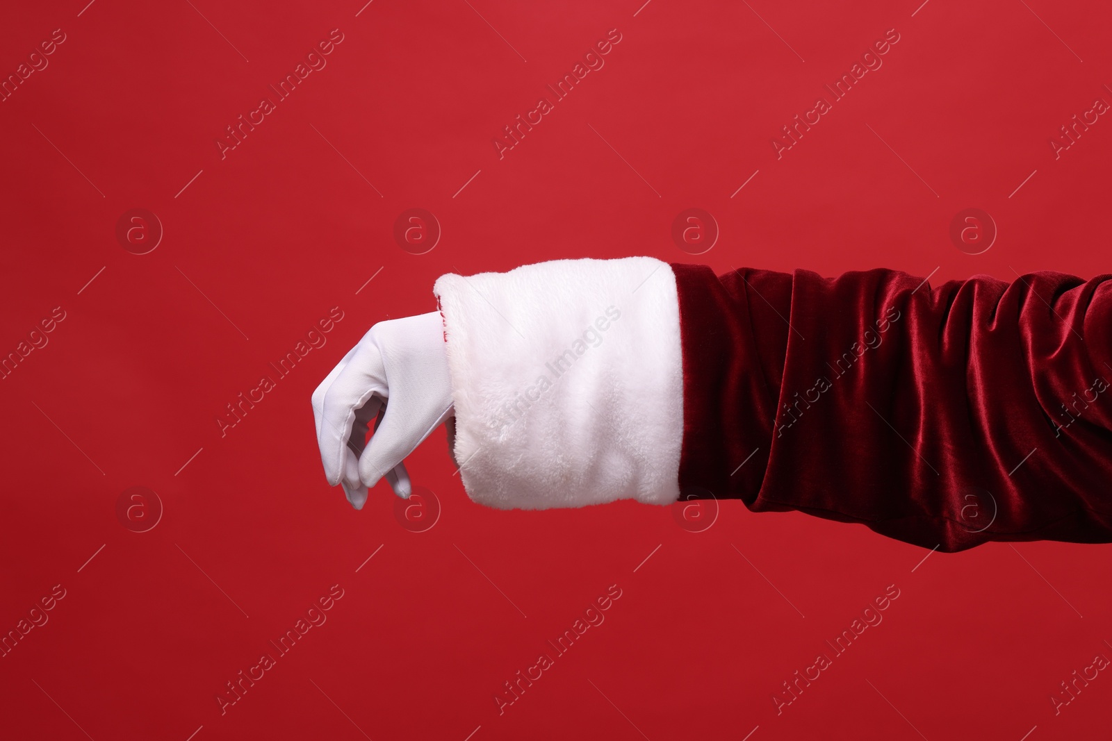 Photo of Santa Claus holding something on red background, closeup