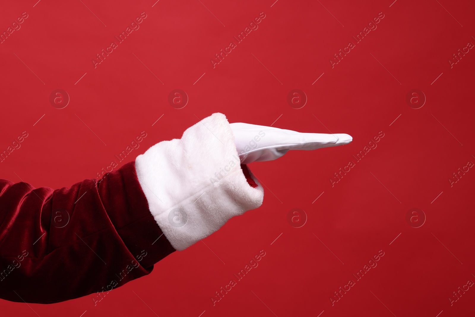 Photo of Santa Claus holding something on red background, closeup