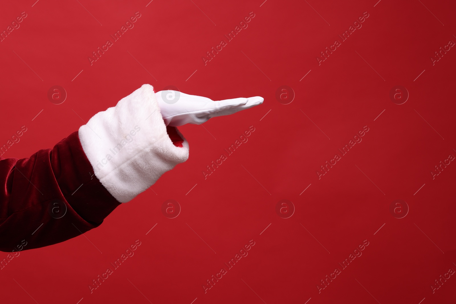 Photo of Santa Claus holding something on red background, closeup. Space for text