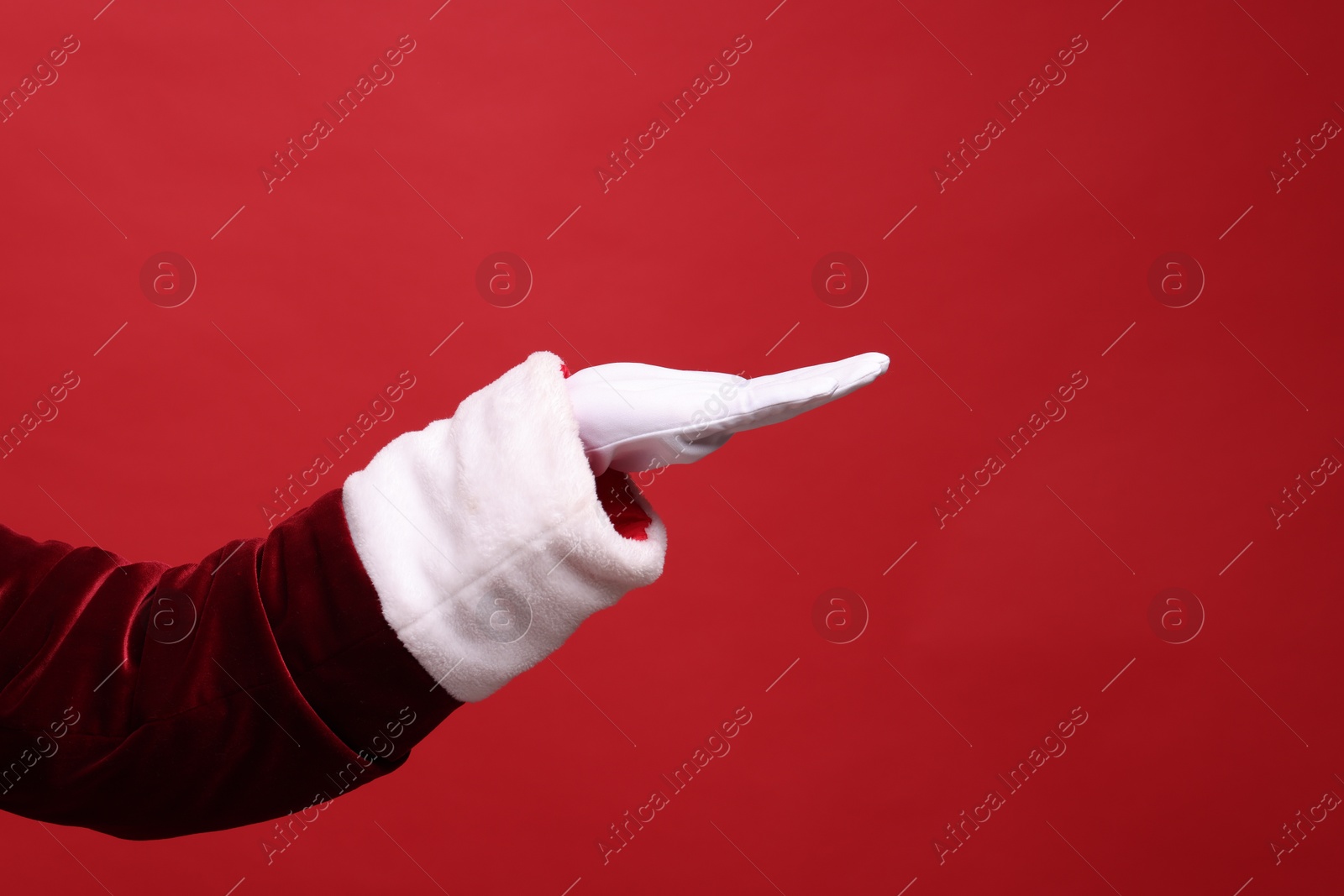 Photo of Santa Claus holding something on red background, closeup. Space for text