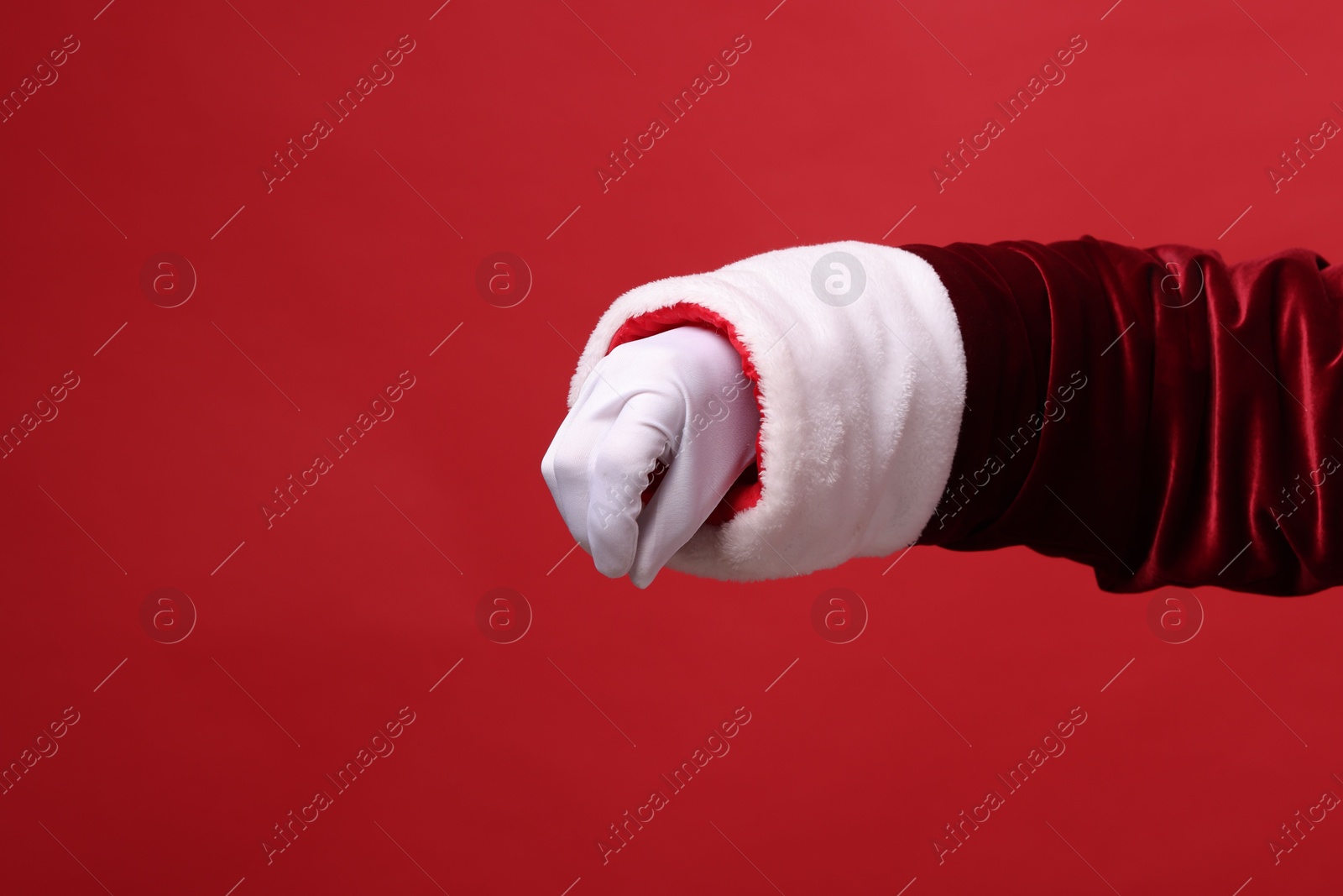 Photo of Santa Claus holding something on red background, closeup. Space for text