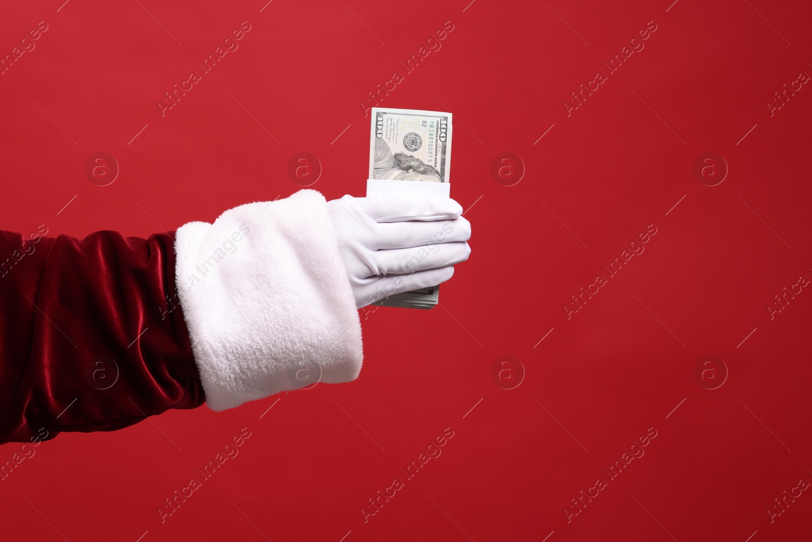 Photo of Santa Claus with dollar banknotes on red background, closeup. Space for text