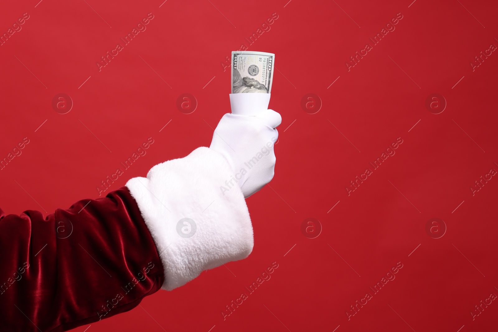 Photo of Santa Claus with dollar banknotes on red background, closeup. Space for text