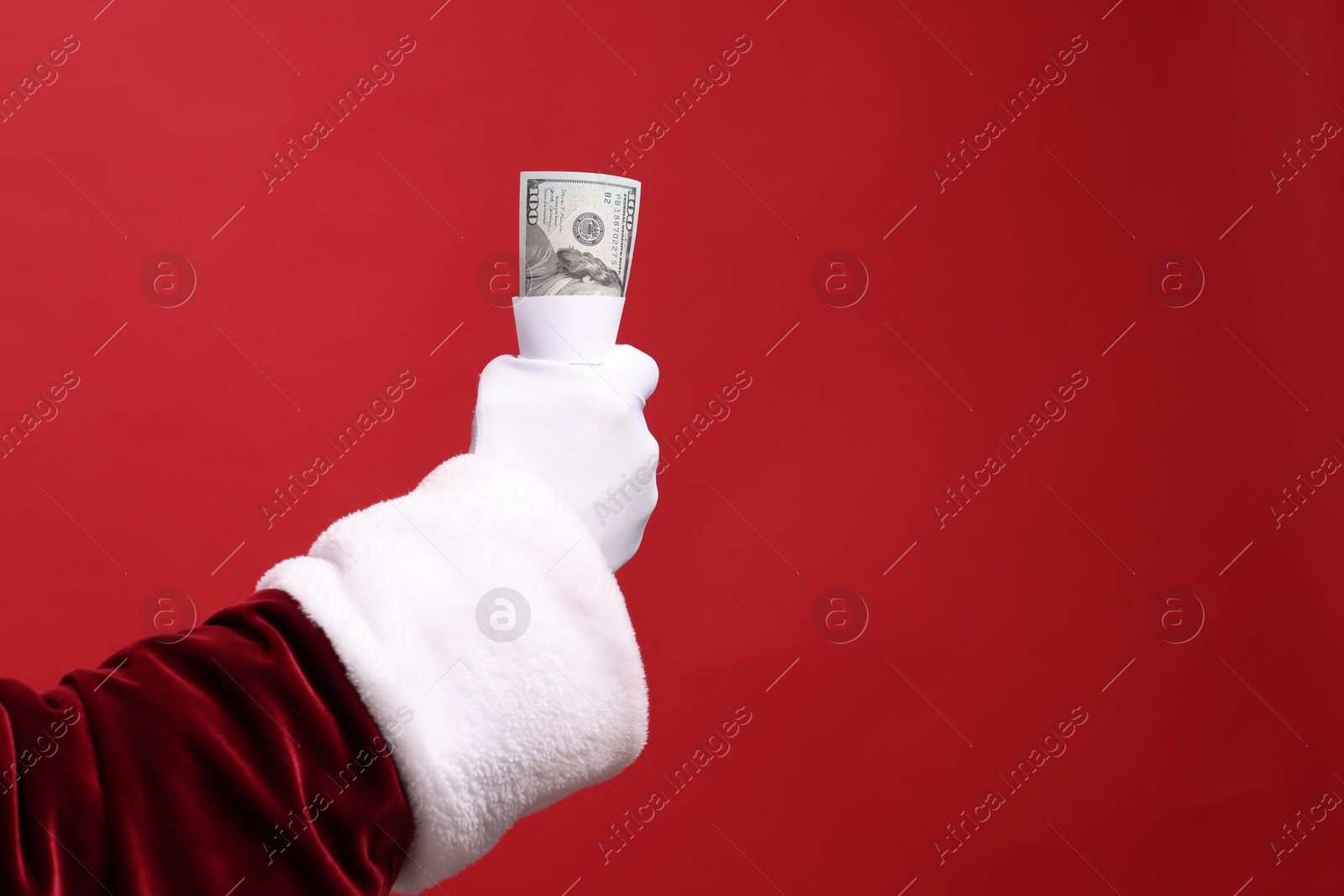 Photo of Santa Claus with dollar banknotes on red background, closeup. Space for text