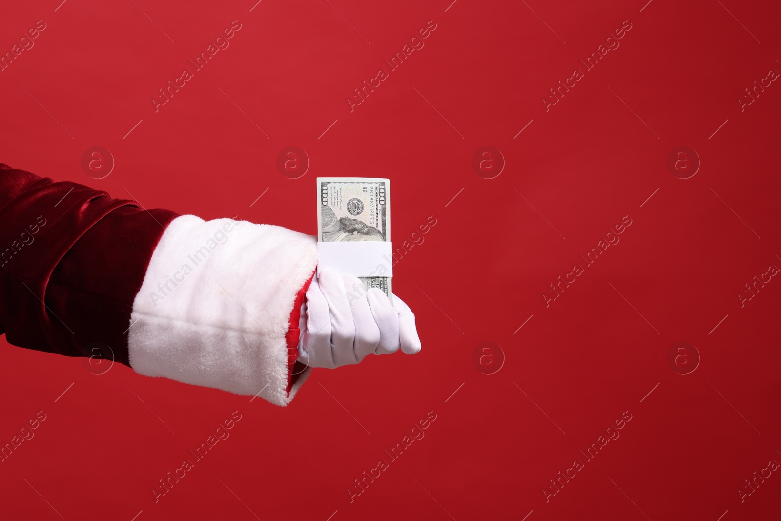 Photo of Santa Claus with dollar banknotes on red background, closeup. Space for text