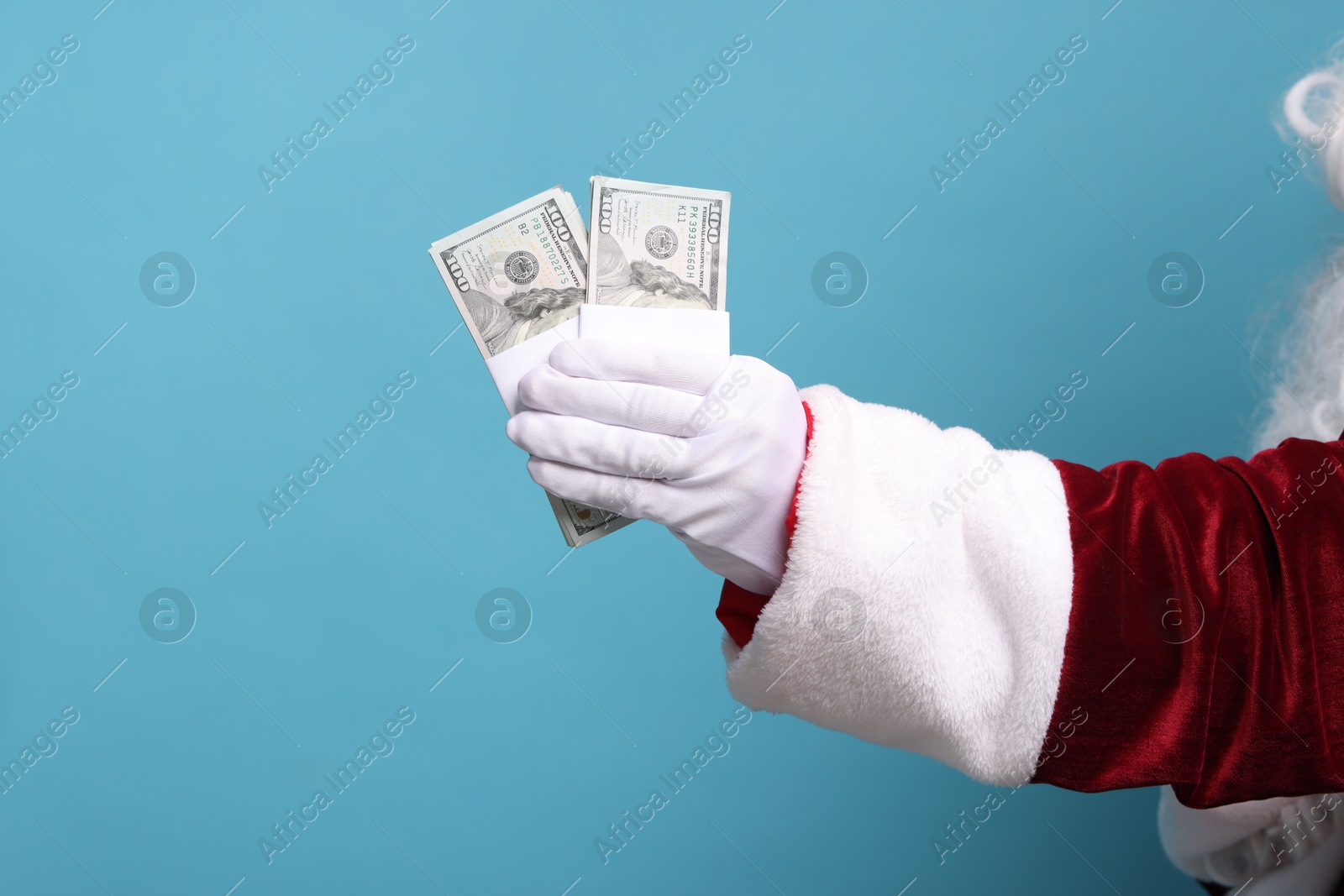 Photo of Santa Claus with dollar banknotes on light blue background, closeup. Space for text