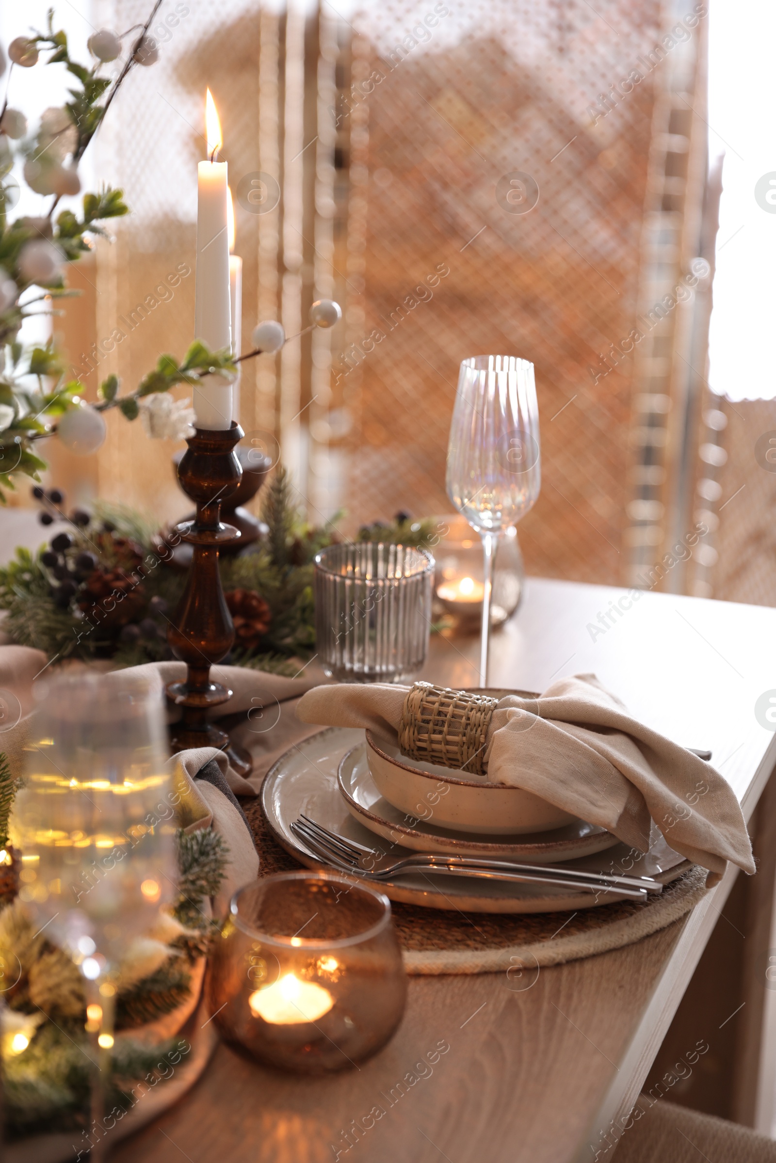 Photo of Christmas place setting with festive decor on wooden table in room