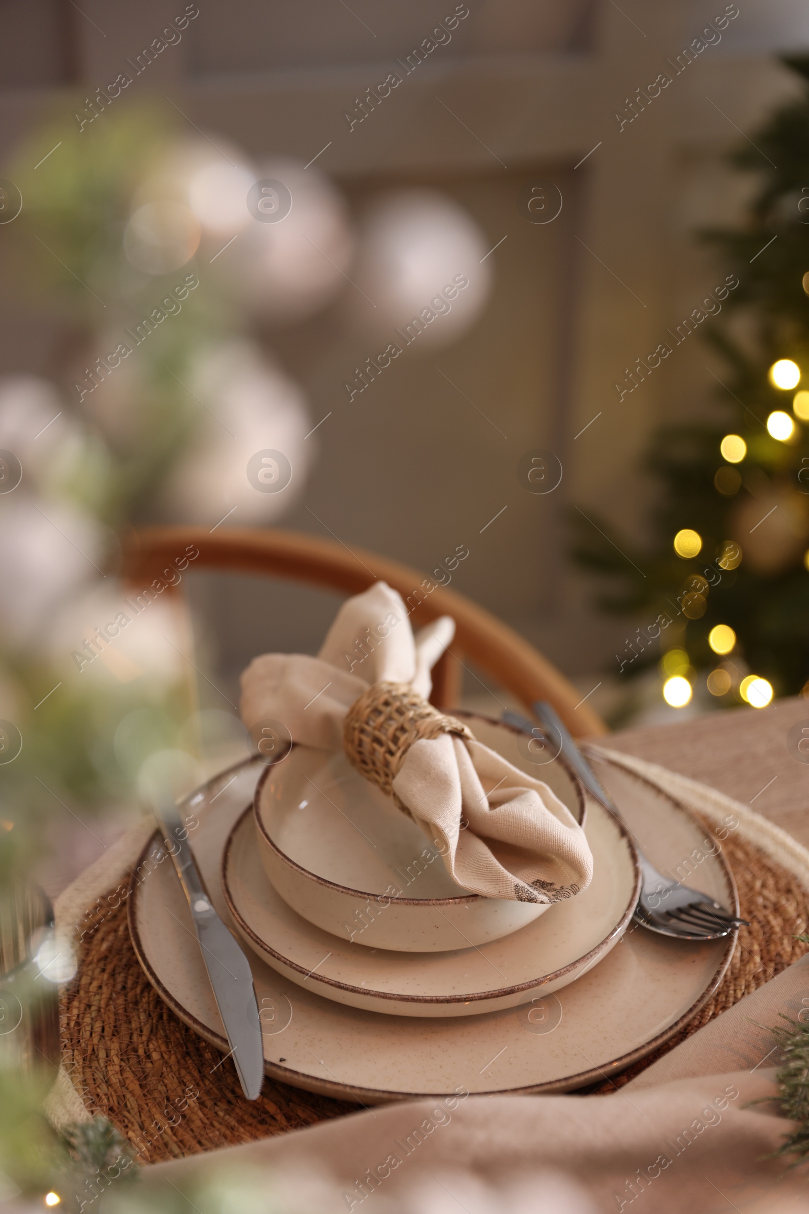 Photo of Christmas place setting with festive decor on table in room