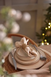 Photo of Christmas place setting with festive decor on table in room