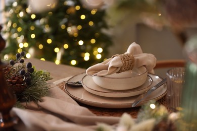 Photo of Christmas place setting with festive decor on table in room