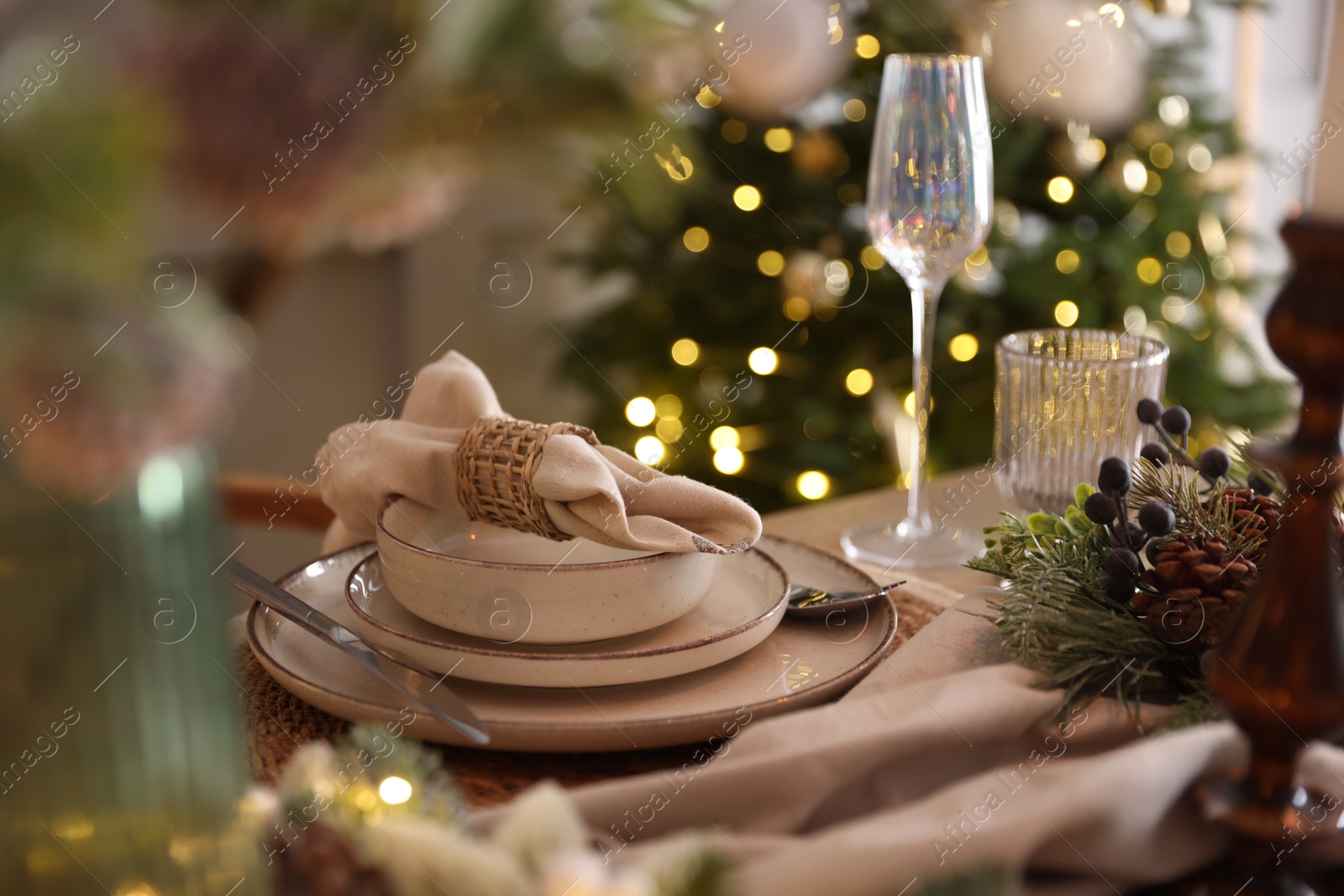 Photo of Christmas place setting with festive decor on table in room, closeup