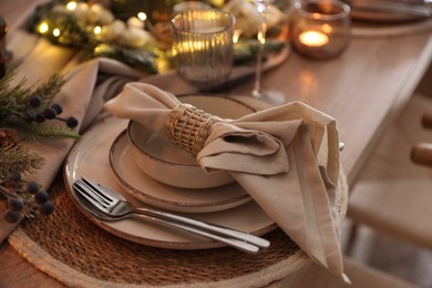 Photo of Christmas place setting with festive decor on table in room, closeup