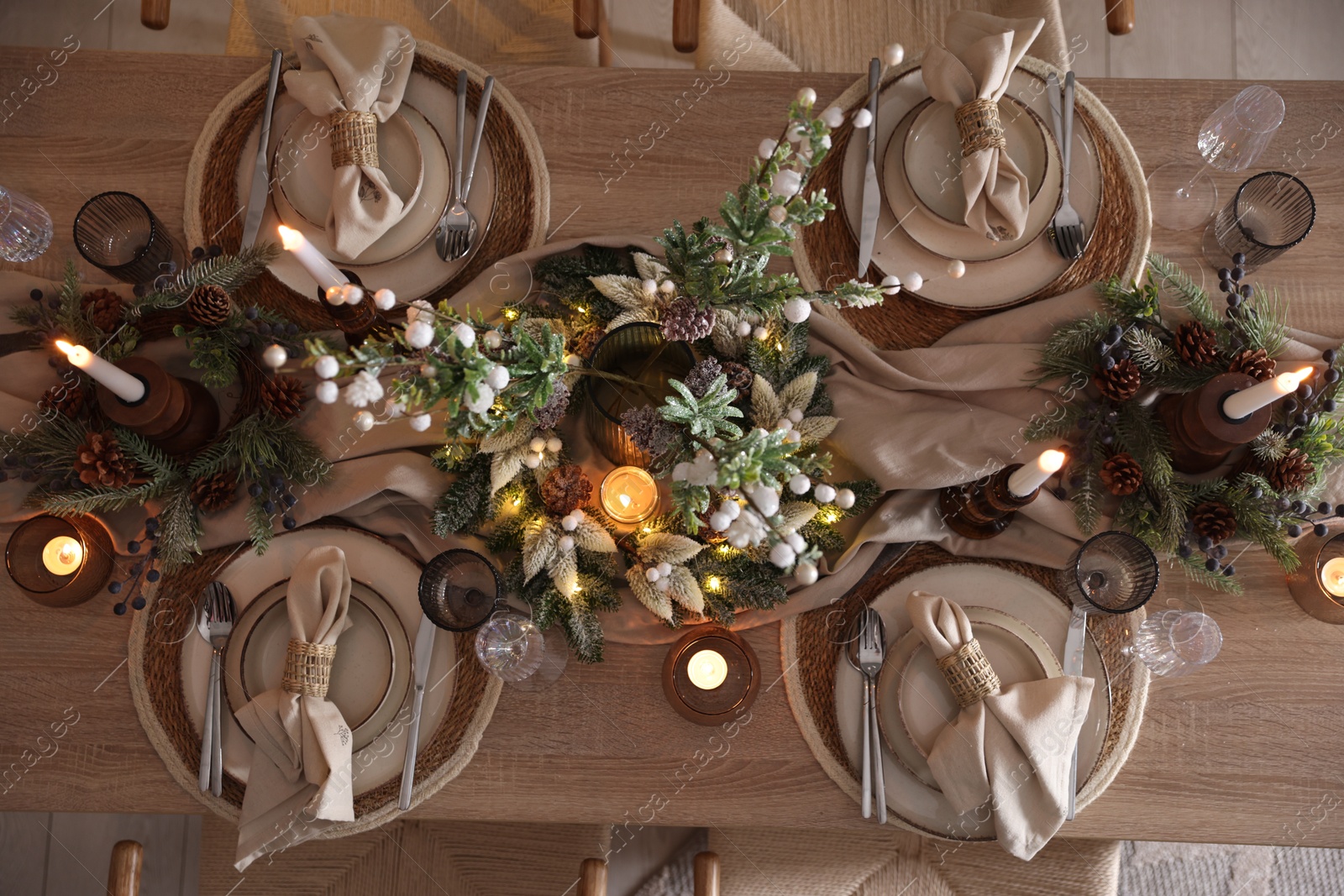 Photo of Christmas celebration. Festive table setting with dishware, glasses and decor in room, top view