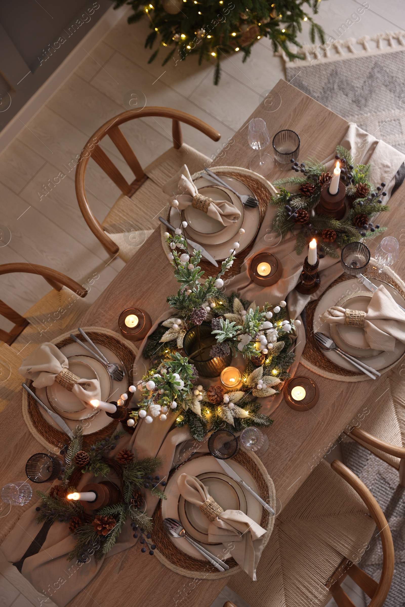 Photo of Christmas celebration. Festive table setting with dishware, glasses and decor in room, top view