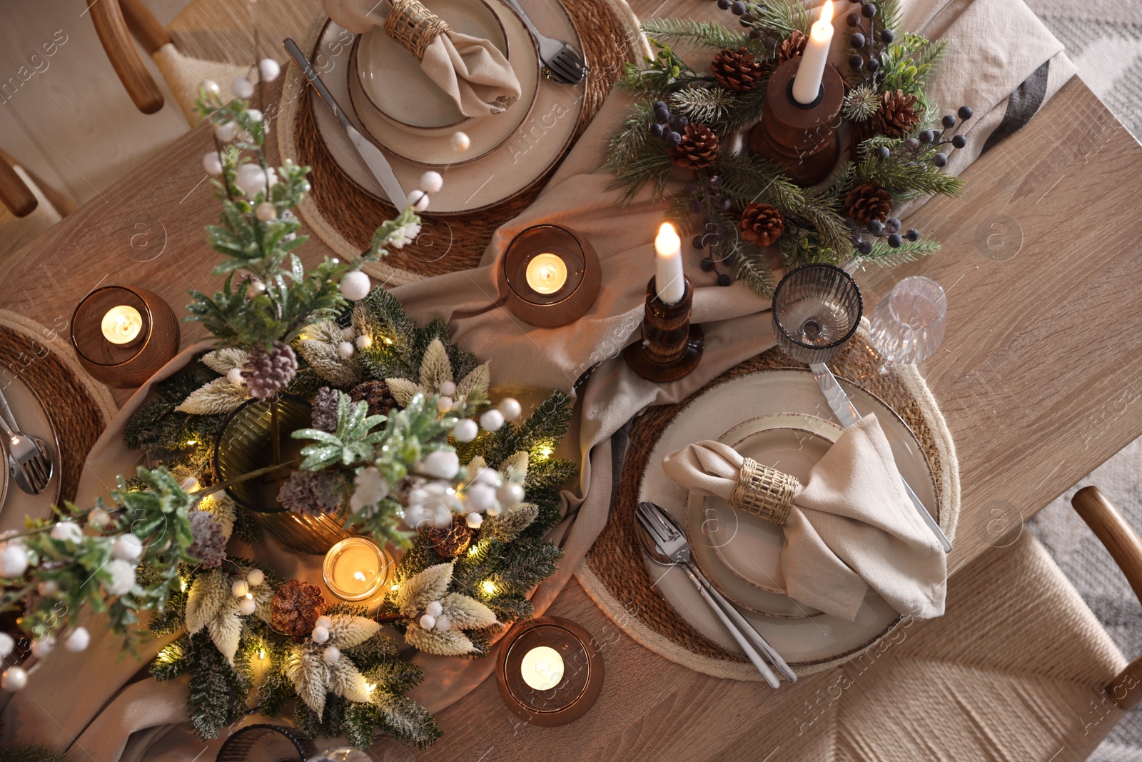 Photo of Christmas celebration. Festive table setting with dishware, glasses and decor in room, top view