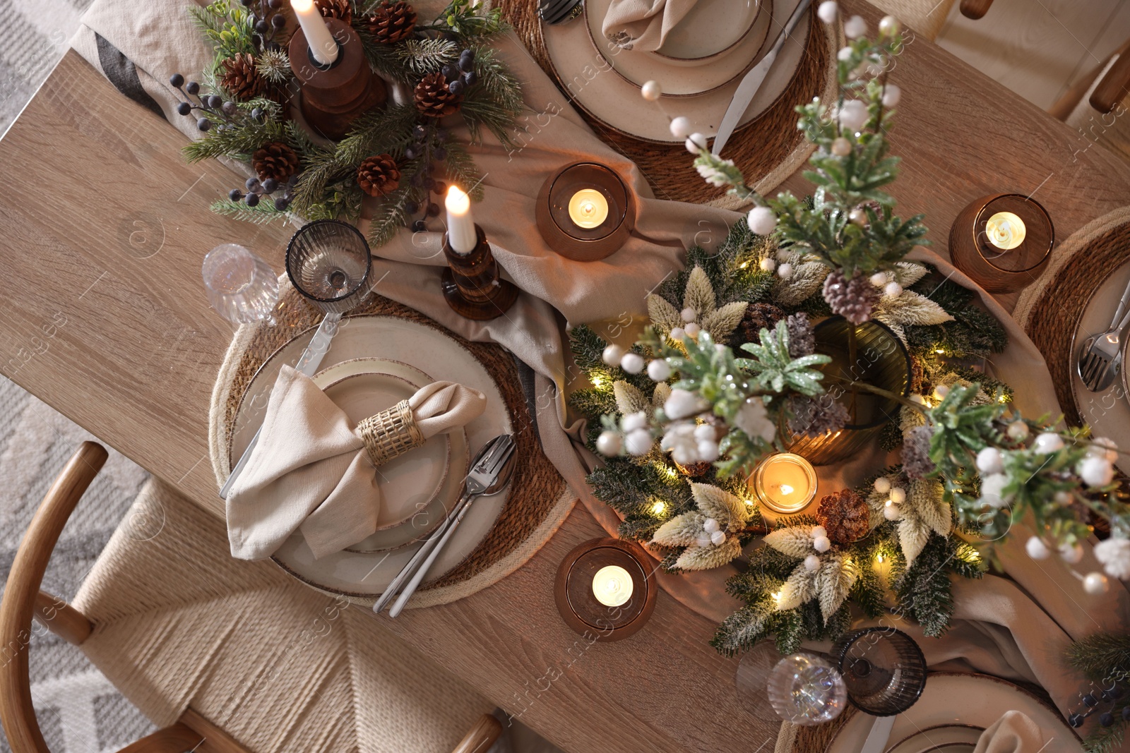 Photo of Christmas celebration. Festive table setting with dishware, glasses and decor in room, top view