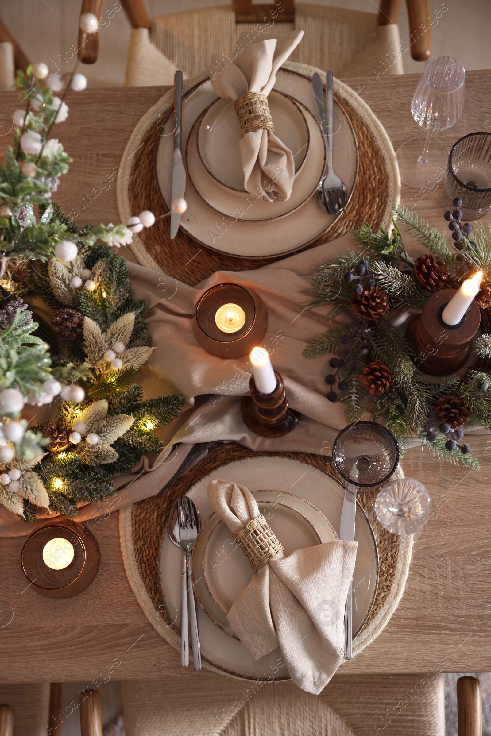 Photo of Christmas celebration. Festive table setting with dishware, glasses and decor in room, top view