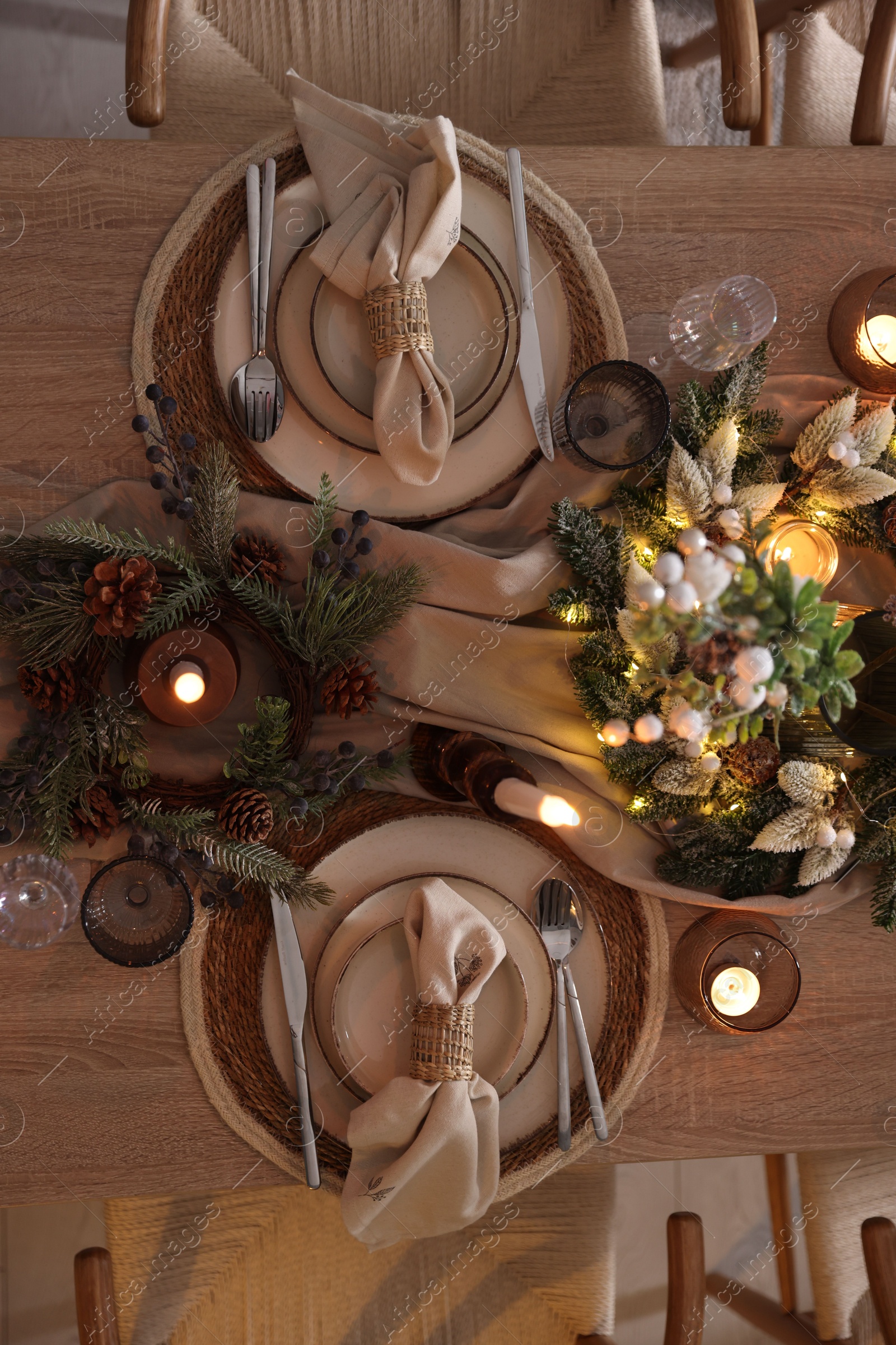 Photo of Christmas celebration. Festive table setting with dishware, glasses and decor in room, top view