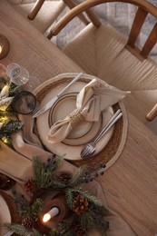 Photo of Christmas celebration. Festive table setting with dishware, glasses and decor in room, top view