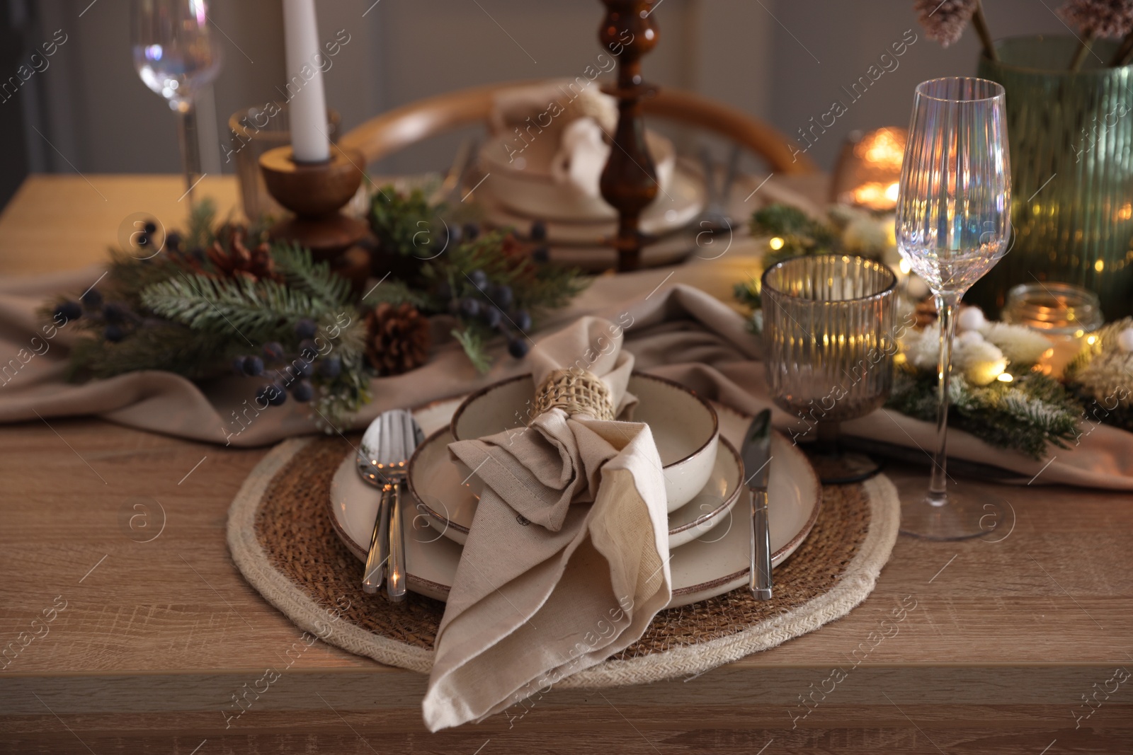 Photo of Christmas celebration. Festive table setting with dishware, glasses and decor in room