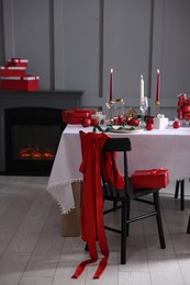 Photo of Christmas celebration. Festive table setting with dishware, glasses and decor