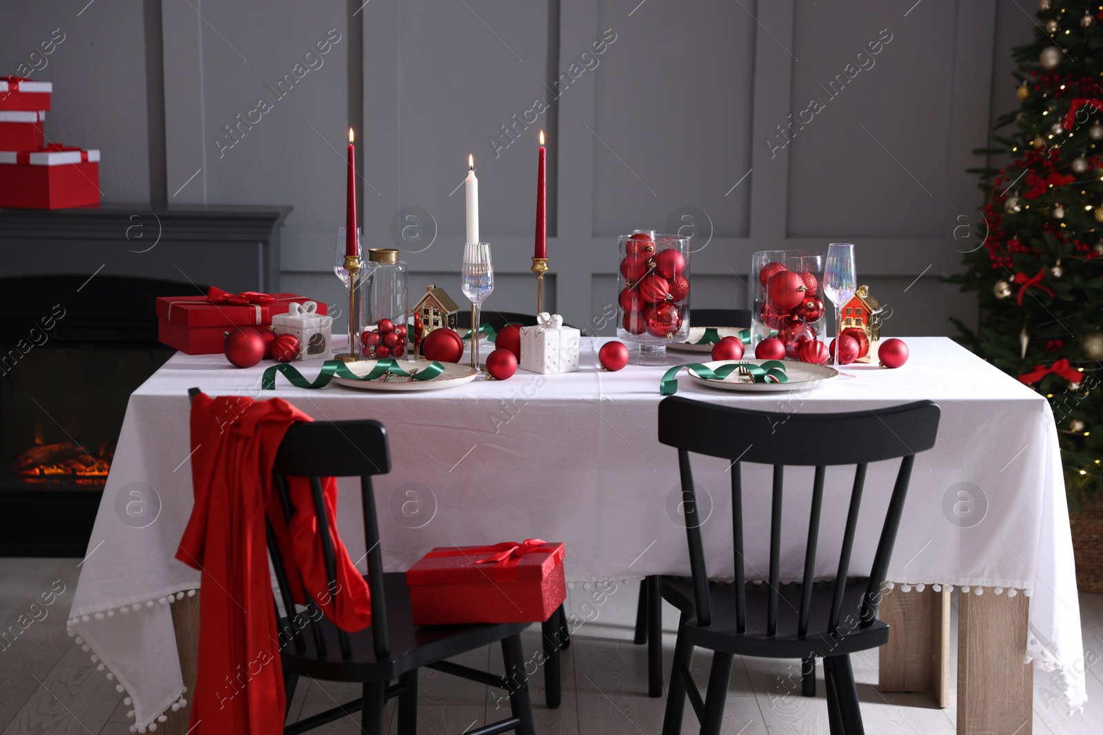 Photo of Christmas celebration. Festive table setting with dishware, glasses and decor