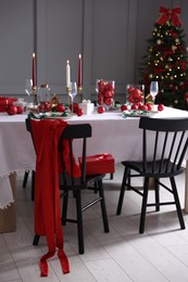 Photo of Christmas celebration. Festive table setting with dishware, glasses and decor