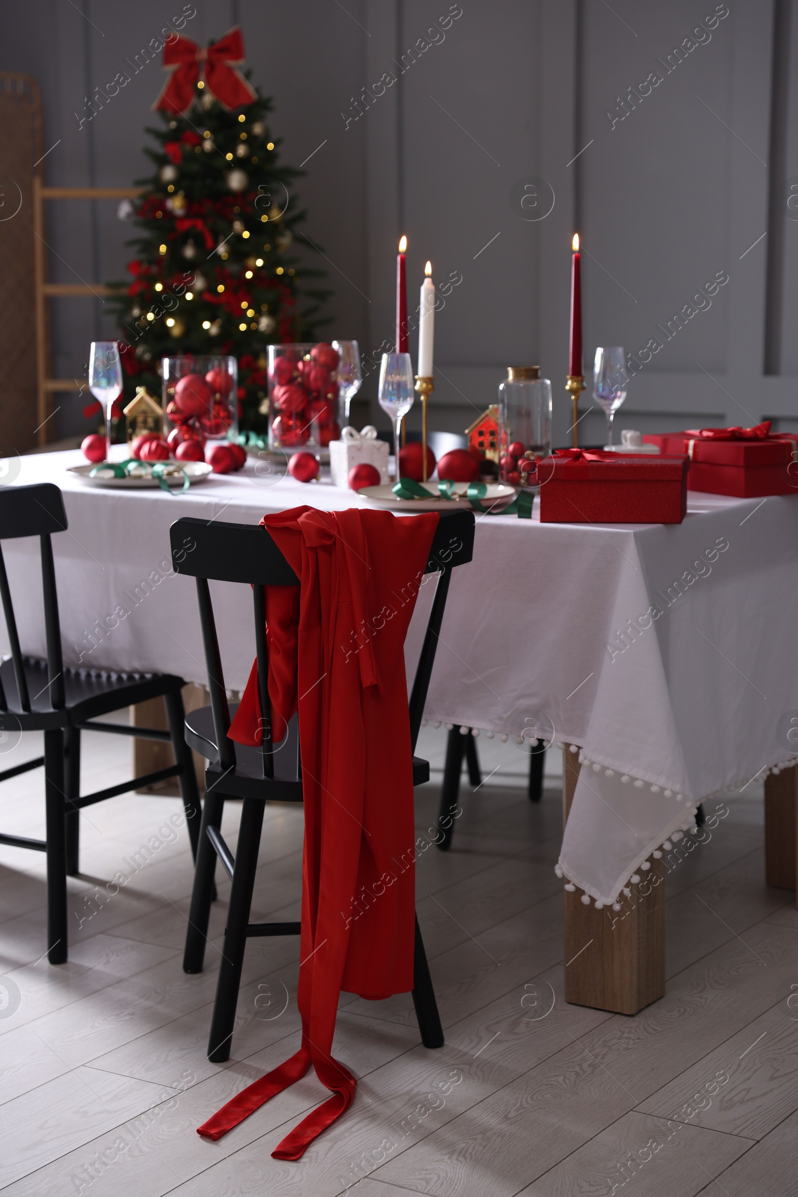 Photo of Christmas celebration. Festive table setting with dishware, glasses and decor