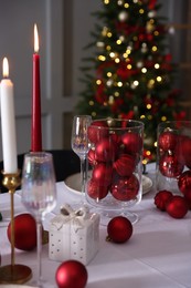 Photo of Christmas place setting with festive decor on table in room