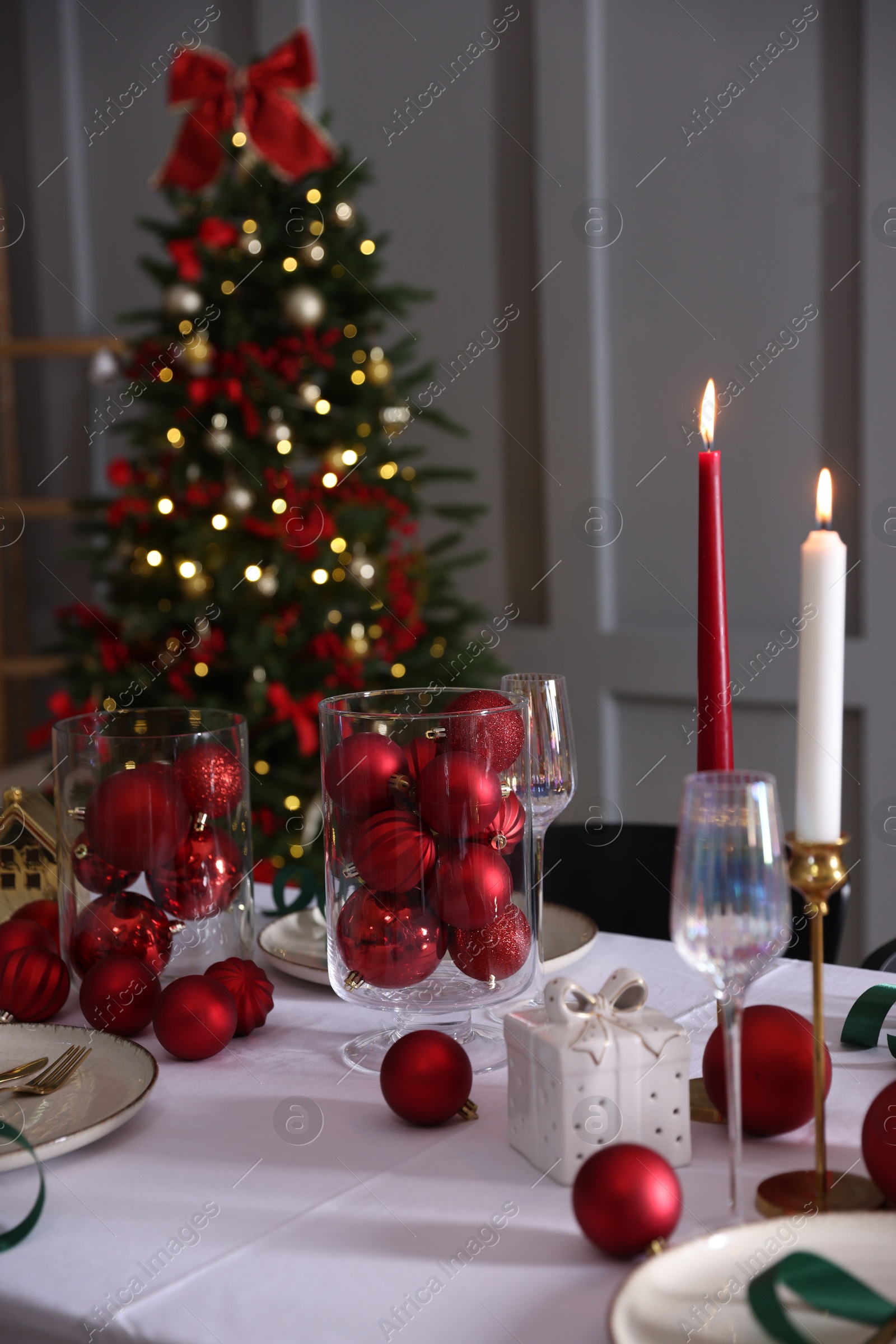 Photo of Christmas place setting with festive decor on table in room