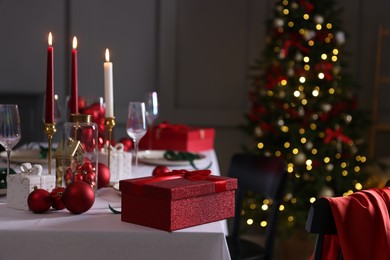 Photo of Christmas place setting with festive decor on table in room