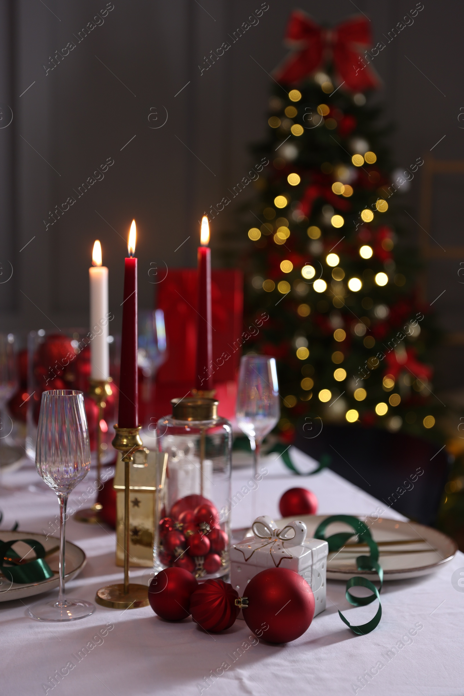 Photo of Christmas place setting with festive decor on table in room