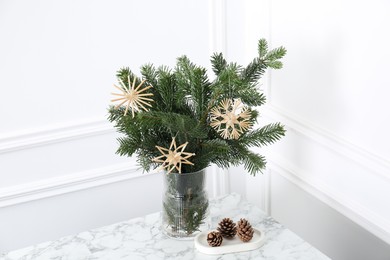 Photo of Beautiful decorated fir tree branches and cones on white table. Christmas season