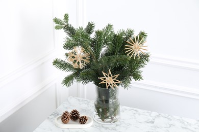 Photo of Beautiful decorated fir tree branches and cones on white table. Christmas season