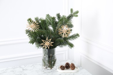 Photo of Beautiful decorated fir tree branches and cones on white table. Christmas season