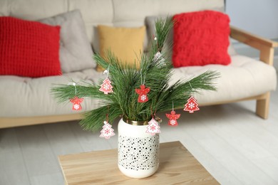 Decorated pine tree branches on table at home. Christmas decor