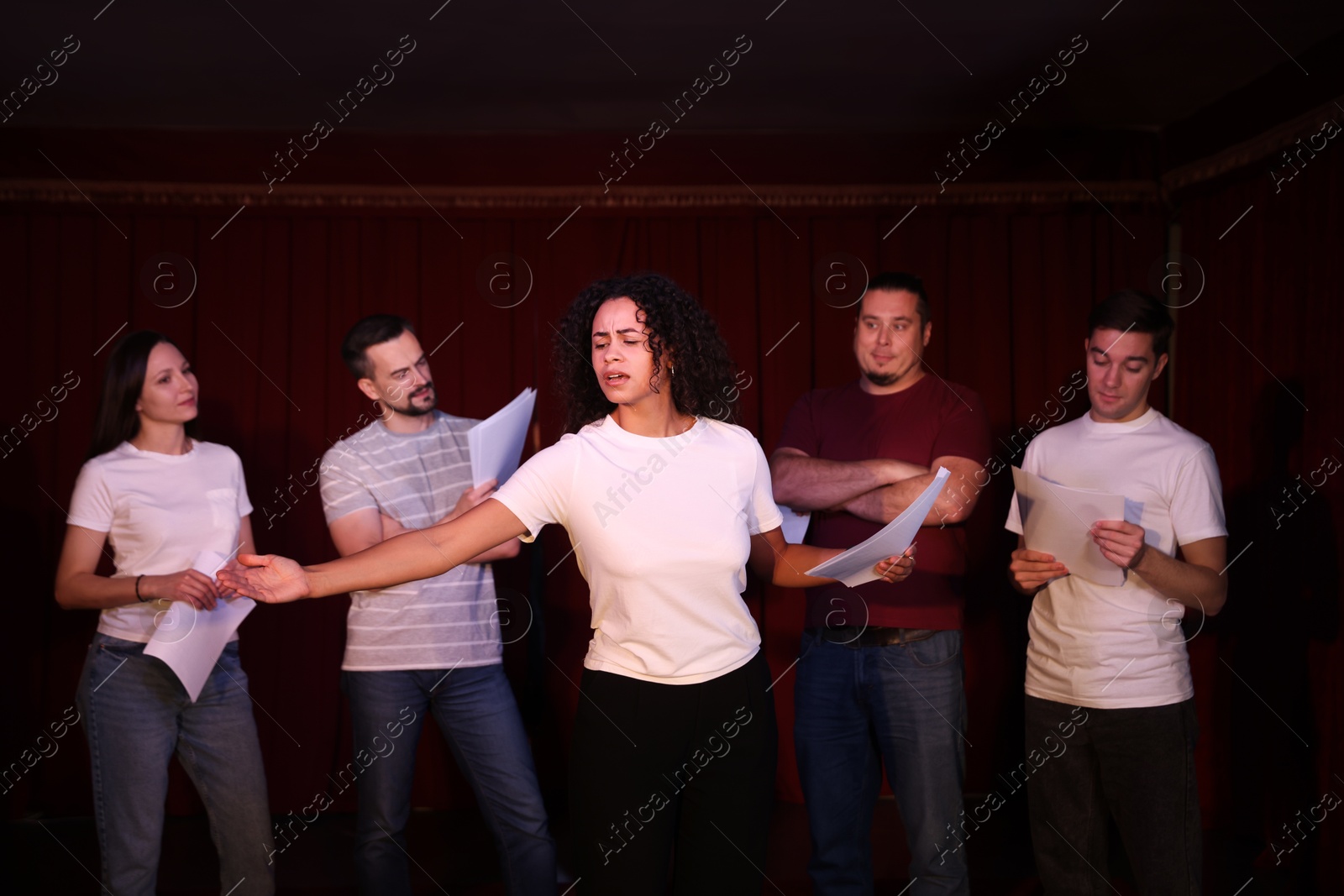 Photo of Professional actors with their scripts rehearsing in theatre