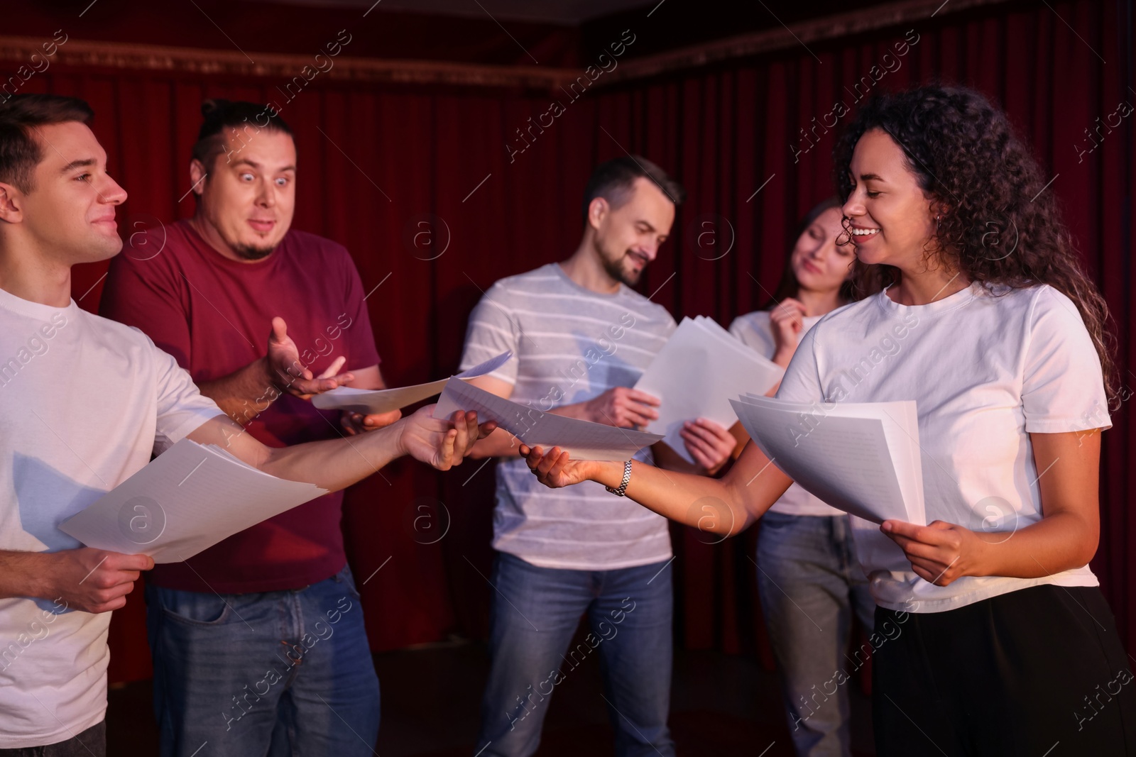 Photo of Professional actors with their scripts rehearsing in theatre