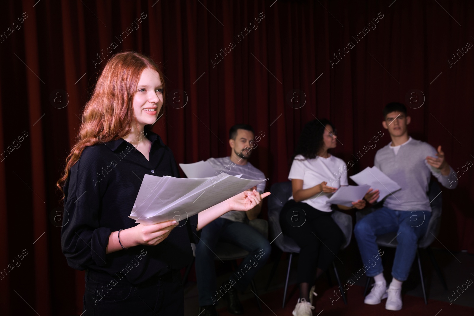 Photo of Professional actors reading their scripts during rehearsal in theatre