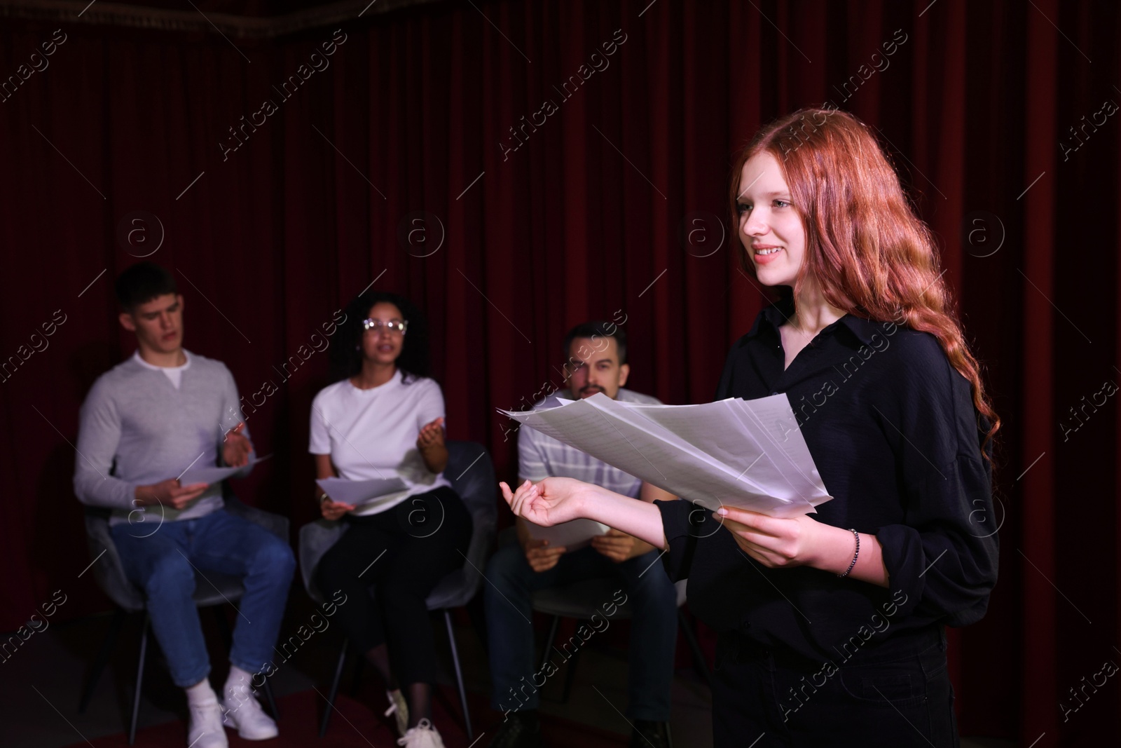 Photo of Professional actors reading their scripts during rehearsal in theatre