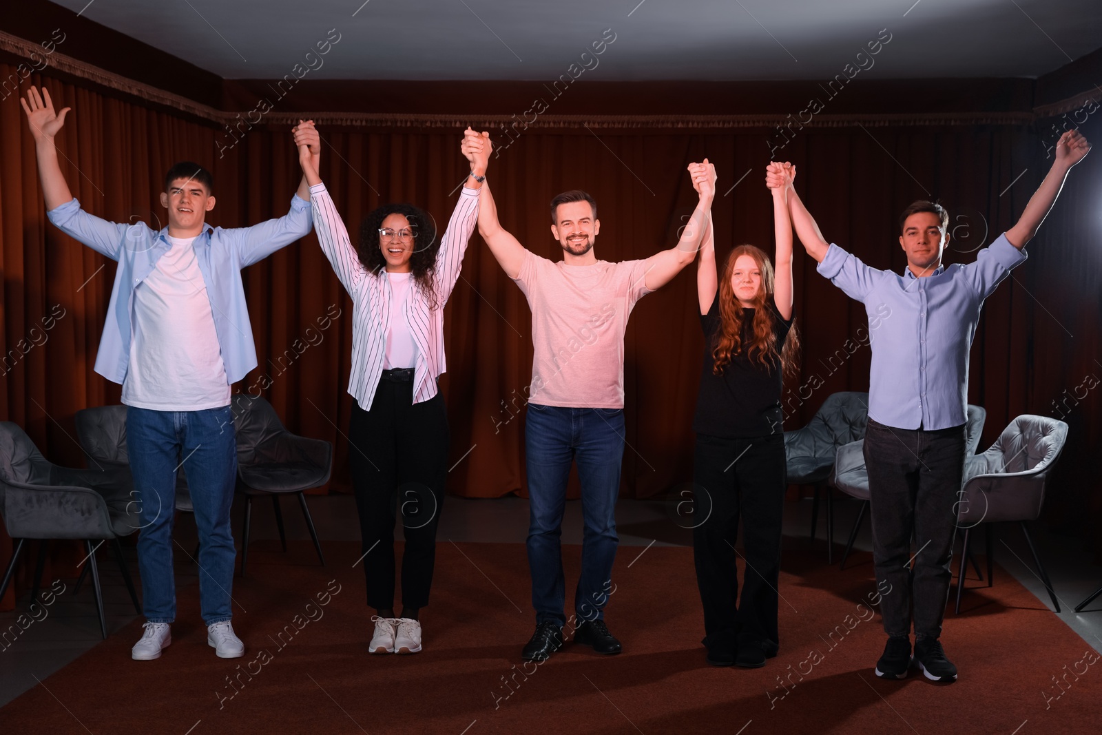 Photo of Professional actors bowing on stage in theatre