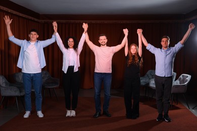 Professional actors bowing on stage in theatre